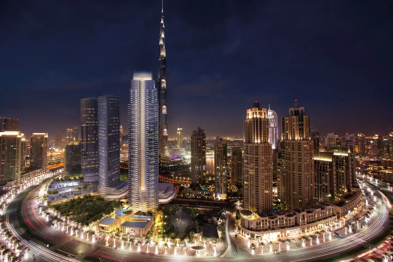 Dubai city skyline at night with illuminated skyscrapers and vibrant city lights, showcasing luxury real estate and urban development.