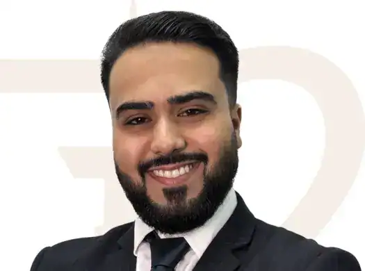 Modern real estate agent in professional suit smiling; expert in property sales and market trends at Seventy Two Real Estate.
